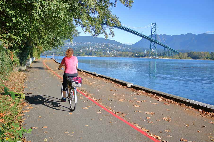 A cyclist travels on the Stanley Park seawall in in Vancouver, BC